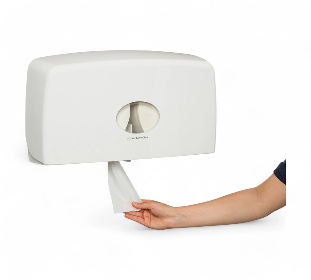 Side-view of a KIMBERLY-CLARK PROFESSIONAL AQUARIUS Twin Jumbo Roll Dispenser (70210) mounted on a wall, with a hand pulling tissue from the bottom opening.
