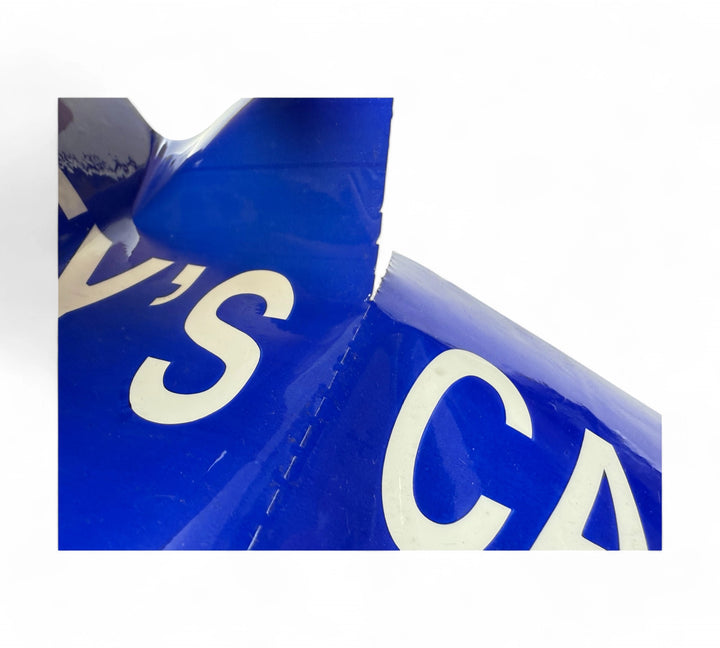 Close-up of a perforated blue CALLEYS' warning sticker with bold white lettering, mid-tear to highlight easy peel separation