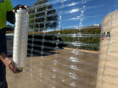 Person wrapping pallet using clear ventilated hand stretch film