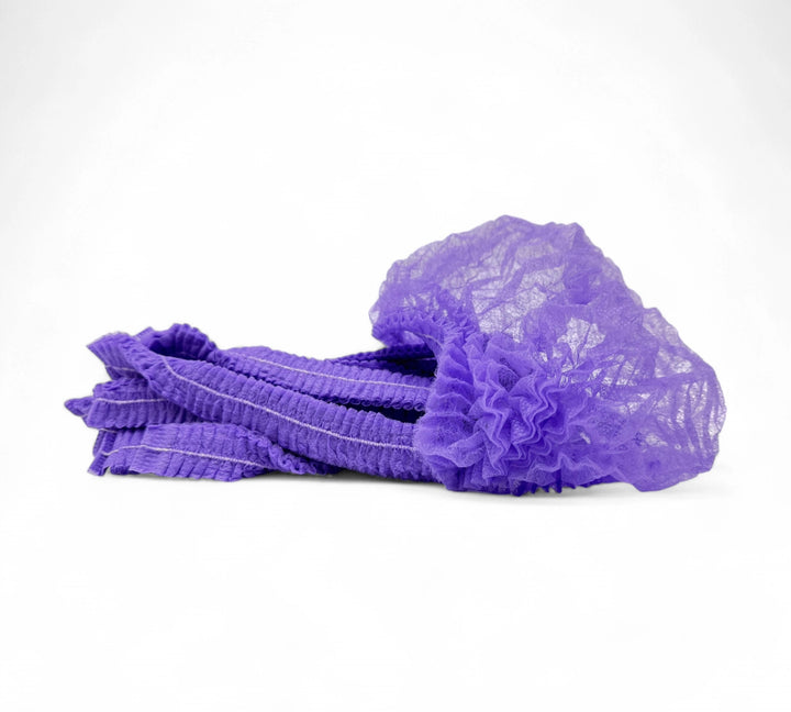 Purple crinkled mop cap hair nets displayed in bulk cartons for colour-coded hygiene in food or medical facilities