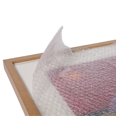 Protective bubble wrap covering a wooden frame for safe packaging